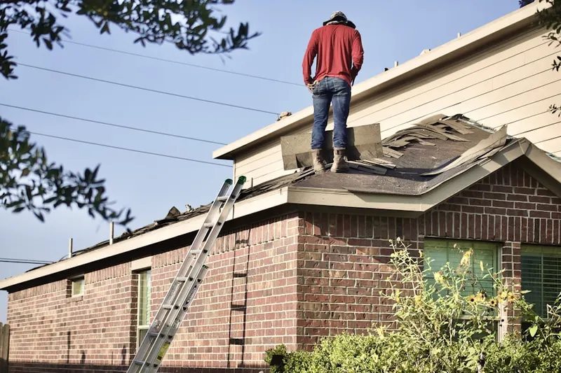 Professional roofer working on a residential roof in Moreau